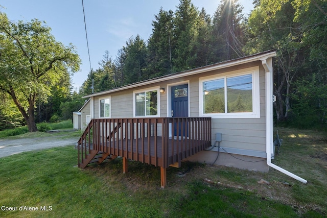 view of front facade featuring a wooden deck and a front lawn