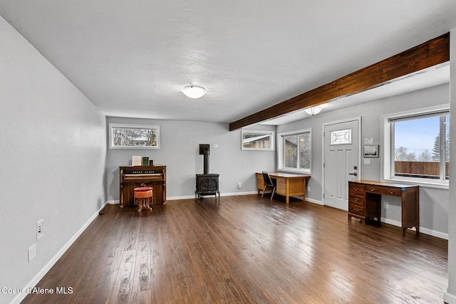 miscellaneous room with dark wood-type flooring, beamed ceiling, and a wood stove