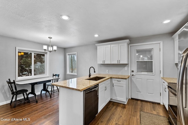 kitchen with decorative light fixtures, sink, white cabinets, and stainless steel dishwasher