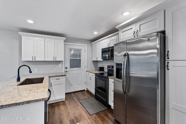 kitchen with stainless steel refrigerator with ice dispenser, white cabinetry, black electric range, and sink