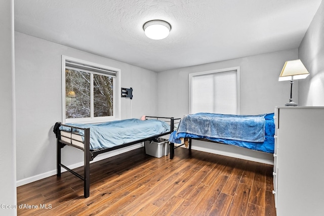 bedroom featuring hardwood / wood-style floors and a textured ceiling