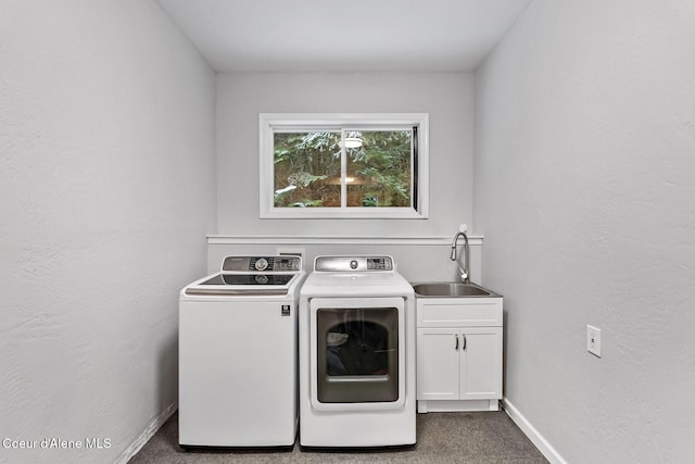 washroom with cabinets, washer and clothes dryer, dark carpet, and sink