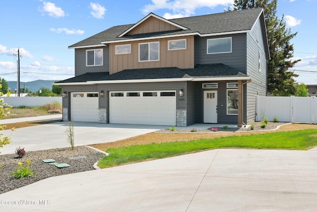 1605 N Garvin Ct, Spokane Valley, WA 99016 - view of front facade with an attached garage, concrete driveway, board and batten siding, stone siding, and a gate
