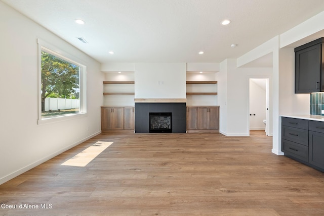 1605 N Garvin Ct, Spokane Valley, WA 99016 - unfurnished living room featuring baseboards, a tile fireplace, light wood-style flooring, and recessed lighting