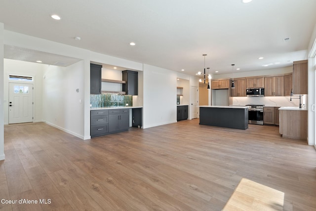 1605 N Garvin Ct, Spokane Valley, WA 99016 - unfurnished living room featuring recessed lighting, baseboards, light wood-type flooring, and a sink
