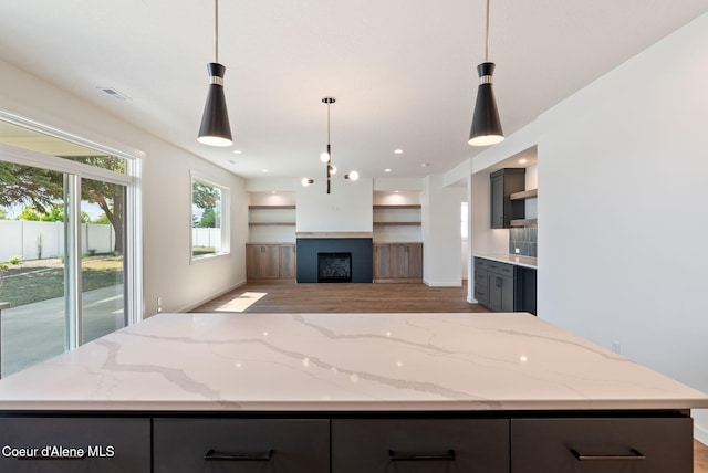 1605 N Garvin Ct, Spokane Valley, WA 99016 - kitchen with wood finished floors, gray cabinets, open floor plan, light stone counters, and a center island