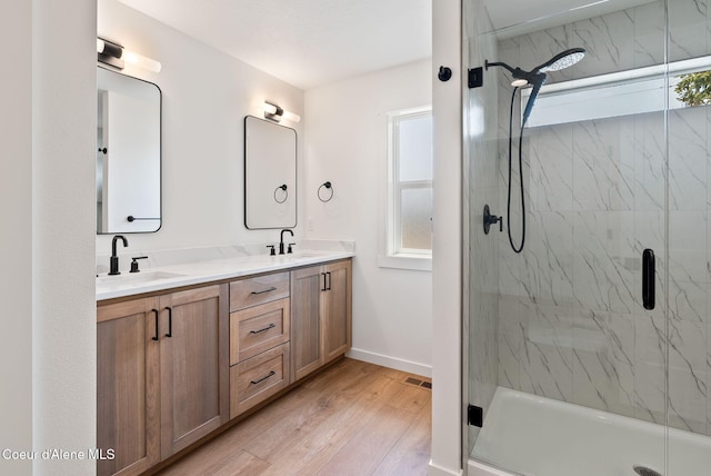 1605 N Garvin Ct, Spokane Valley, WA 99016 - bathroom featuring wood finished floors, a marble finish shower, double vanity, and baseboards