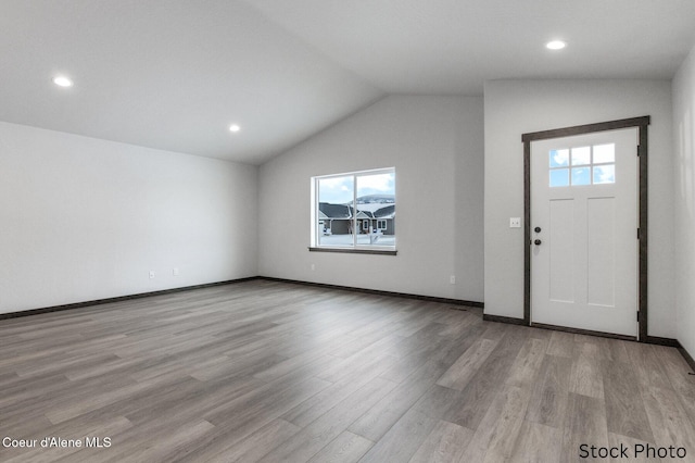 entrance foyer with vaulted ceiling, a healthy amount of sunlight, and light hardwood / wood-style floors