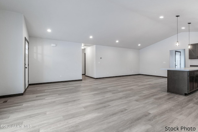 unfurnished living room featuring vaulted ceiling and light wood-type flooring