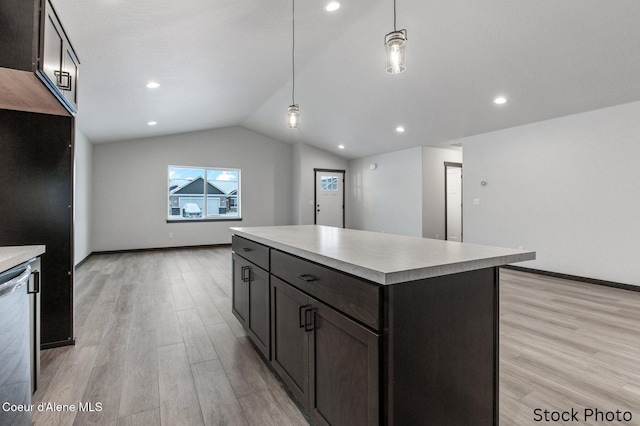 kitchen featuring pendant lighting, lofted ceiling, light hardwood / wood-style floors, a kitchen island, and stainless steel dishwasher