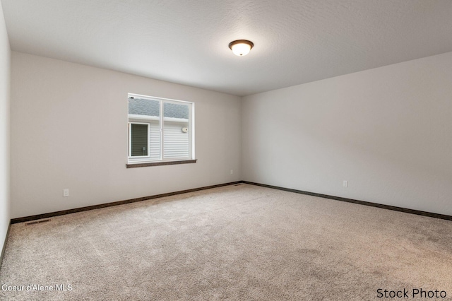 spare room featuring a textured ceiling and carpet