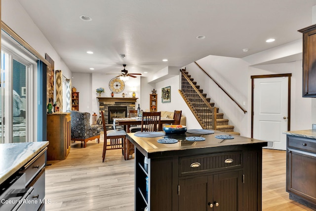 kitchen featuring recessed lighting, a fireplace, light wood-type flooring, and ceiling fan