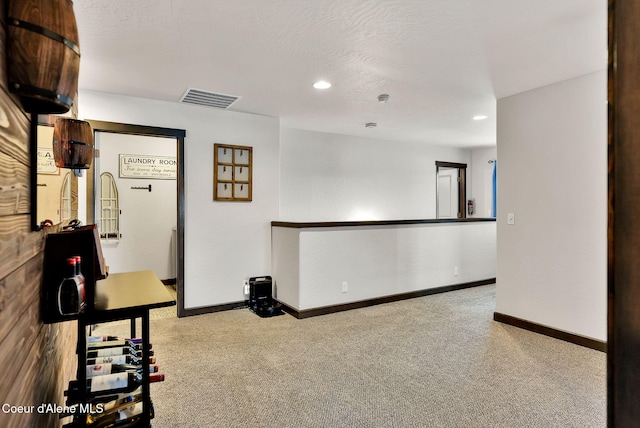 workout area with visible vents, a textured ceiling, baseboards, and carpet floors