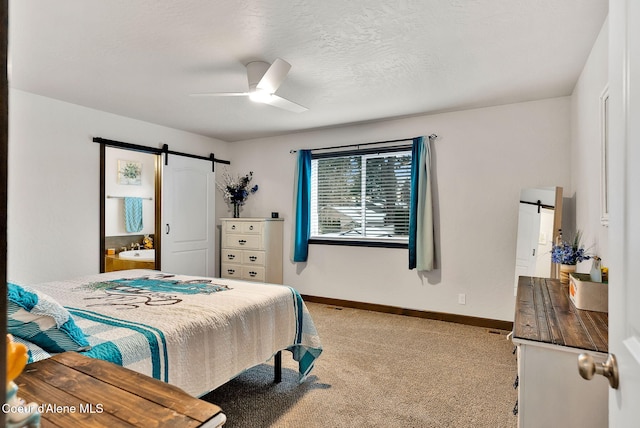 carpeted bedroom with a barn door, baseboards, a textured ceiling, and ceiling fan