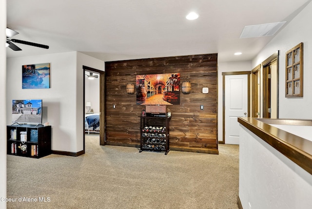 interior space featuring visible vents, baseboards, carpet, wood walls, and recessed lighting