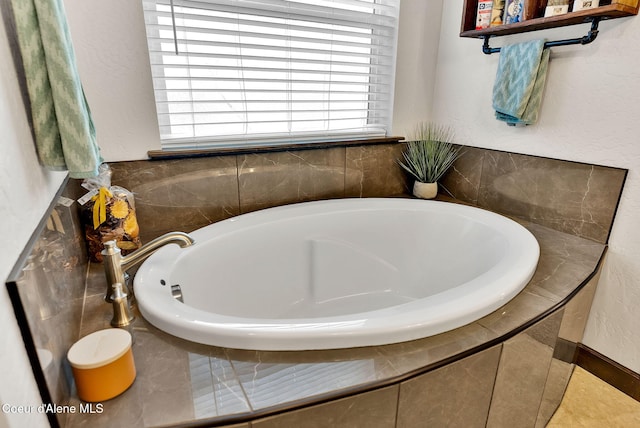 bathroom with a garden tub and a textured wall