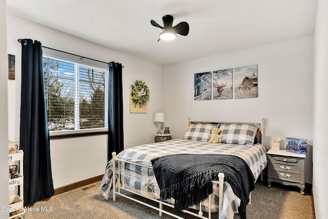 carpeted bedroom with visible vents, baseboards, and a ceiling fan