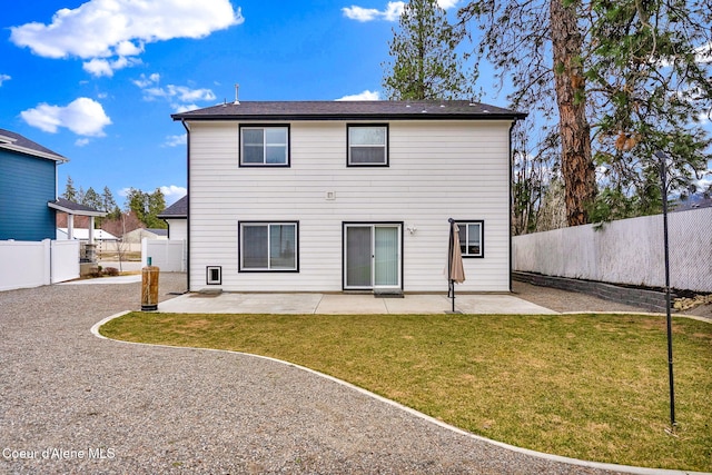 rear view of property with a fenced backyard, a lawn, and a patio