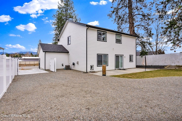 back of house with a mountain view, a fenced backyard, driveway, and a patio area