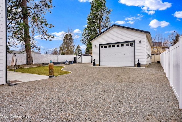 view of yard with an outdoor structure, a fenced backyard, and a garage