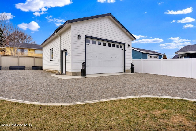 detached garage featuring fence