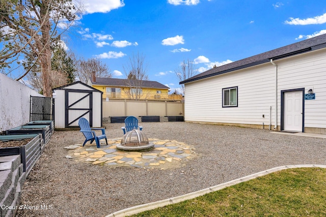 view of yard featuring an outbuilding, a storage shed, a vegetable garden, and fence