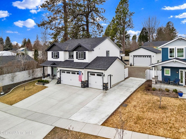 traditional home featuring a residential view, roof with shingles, driveway, and fence