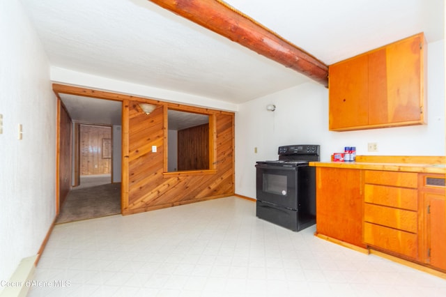 kitchen featuring beam ceiling, black range with electric cooktop, and wood walls