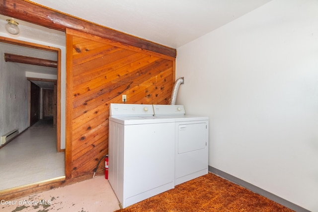 washroom with washing machine and clothes dryer, wood walls, and baseboard heating