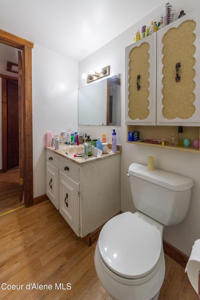 bathroom with hardwood / wood-style floors, vanity, and toilet