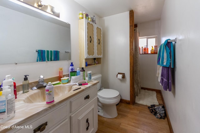 bathroom with wood-type flooring, vanity, and toilet