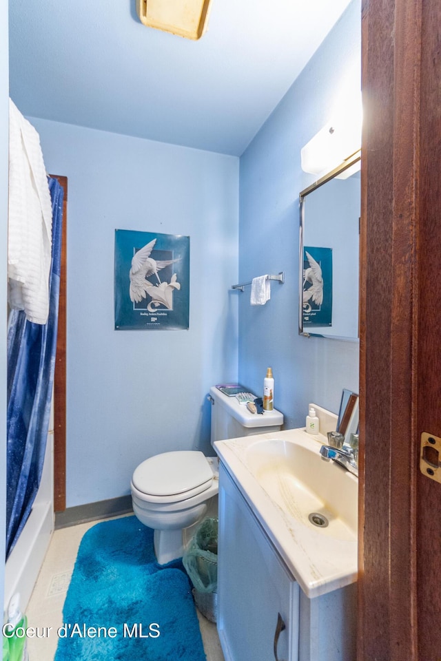 bathroom with vanity, toilet, and curtained shower