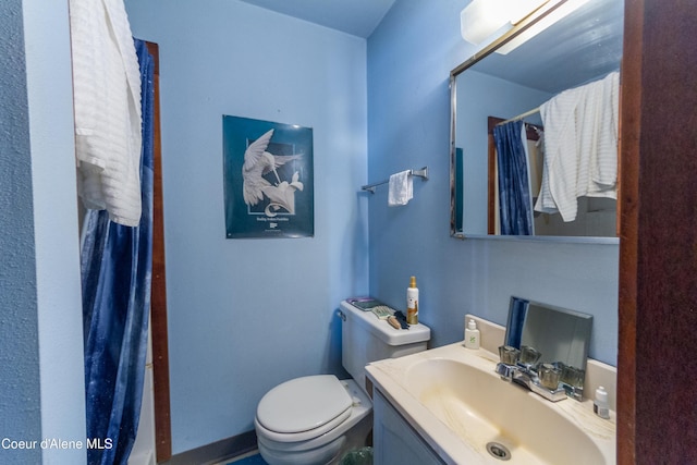 bathroom with a shower with curtain, vanity, and toilet