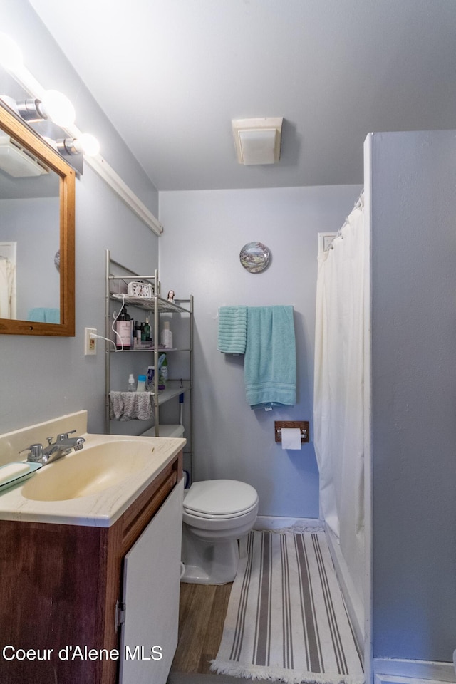 bathroom with hardwood / wood-style flooring, vanity, and toilet