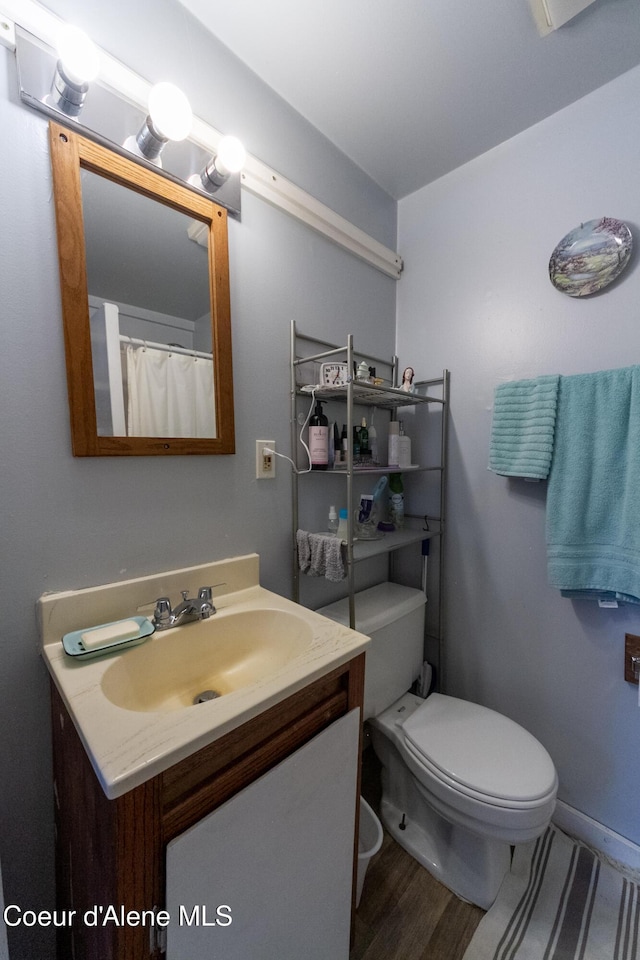 bathroom with vanity, hardwood / wood-style flooring, and toilet