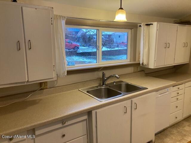 kitchen featuring sink, decorative light fixtures, white cabinetry, and dishwasher