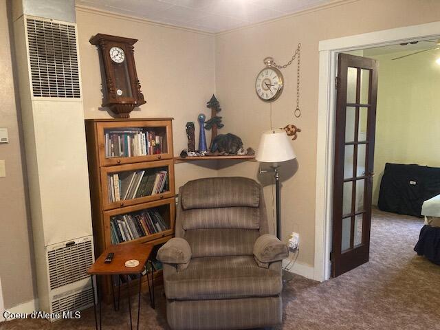 living area with ceiling fan, french doors, crown molding, and carpet flooring