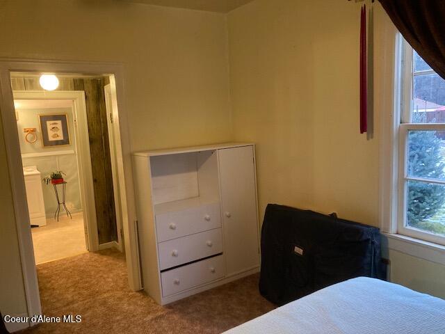 carpeted bedroom with washer / dryer