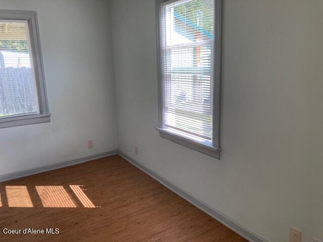 spare room with hardwood / wood-style flooring and plenty of natural light