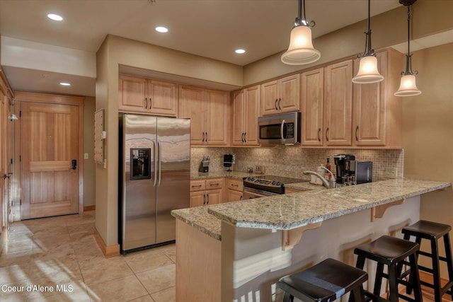 kitchen with light stone countertops, appliances with stainless steel finishes, tasteful backsplash, and light brown cabinets