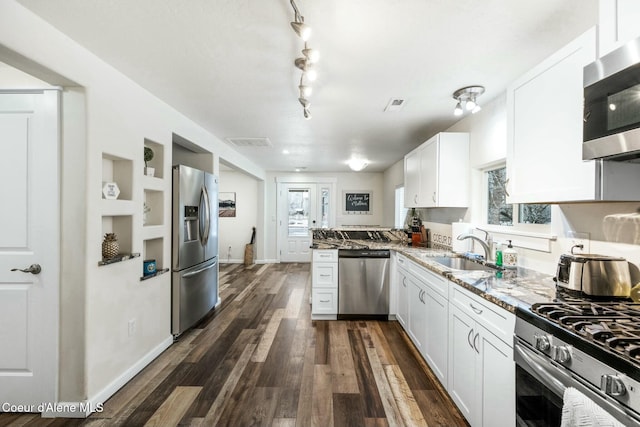 kitchen featuring sink, white cabinetry, appliances with stainless steel finishes, and dark stone counters