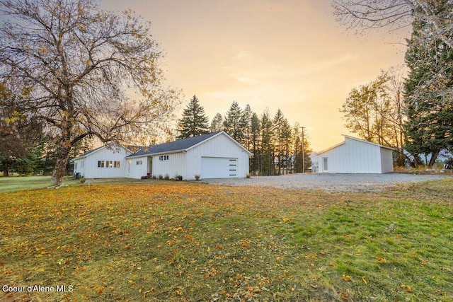 view of front of property featuring a yard, a garage, and an outdoor structure