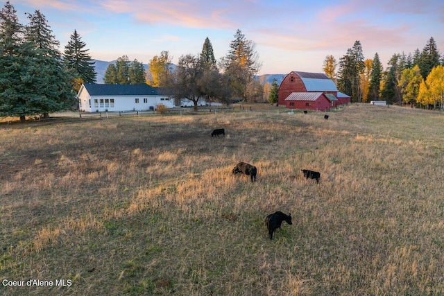 yard at dusk with a rural view and an outbuilding