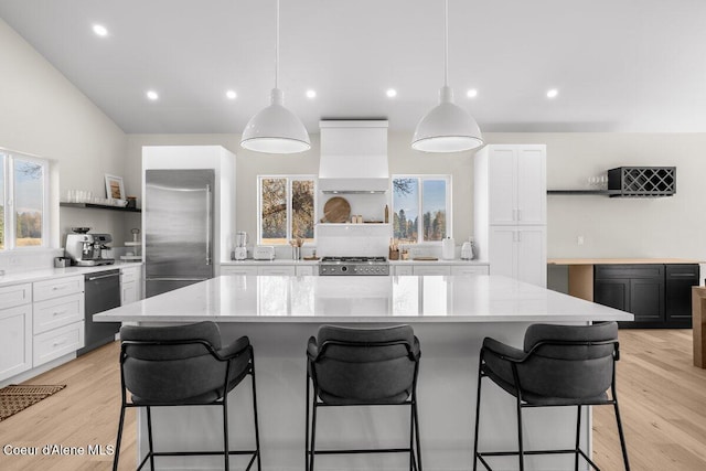 kitchen featuring a kitchen island, white cabinets, built in refrigerator, and black dishwasher