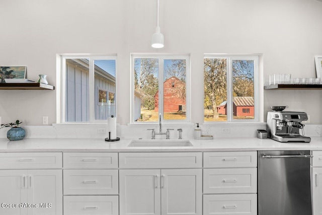 kitchen featuring sink, white cabinetry, and hanging light fixtures