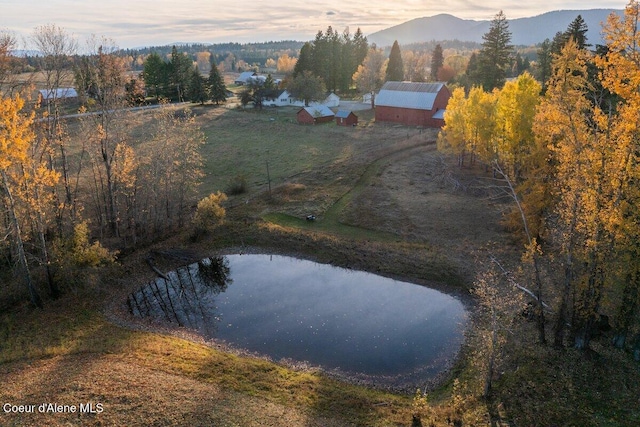 aerial view at dusk featuring a water and mountain view