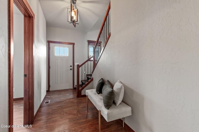 foyer entrance featuring dark hardwood / wood-style floors and lofted ceiling