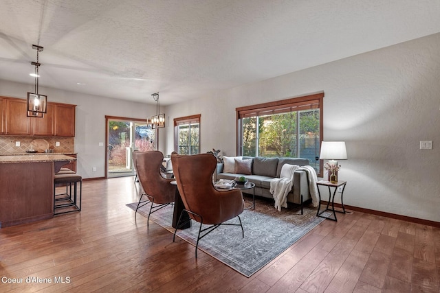 living room with a notable chandelier, a textured ceiling, and dark hardwood / wood-style floors