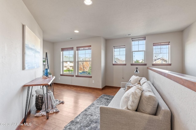 living room featuring a textured ceiling and light hardwood / wood-style flooring