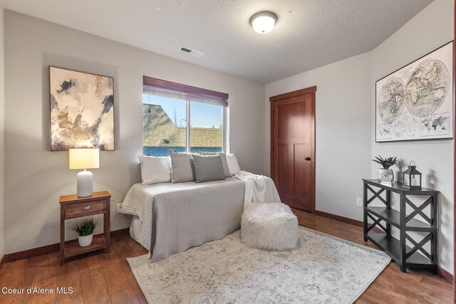 bedroom with dark wood-type flooring and a textured ceiling